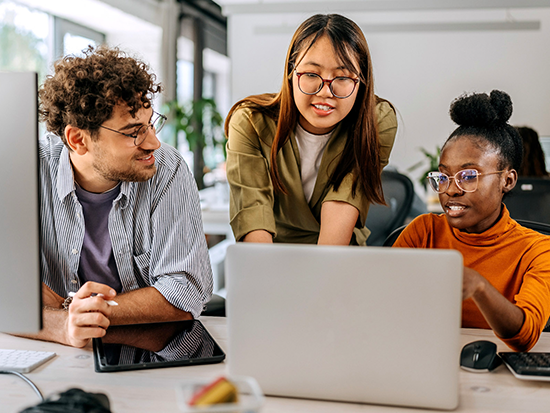 Three students looking at computer