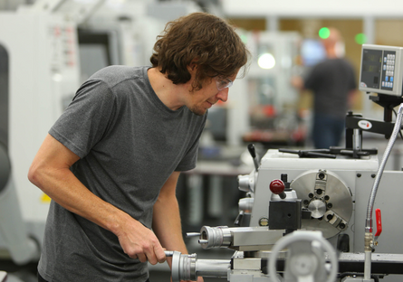 A student using a machine in a workshop