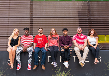 Image of a group of college students sitting on a wall