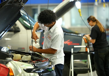 Image of students work on car engines in an Automotive class