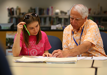 A male teacher working one-on-one with a female student