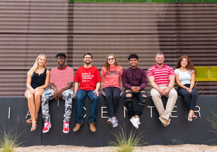 An image of Glendale Community College students sitting in a row outside