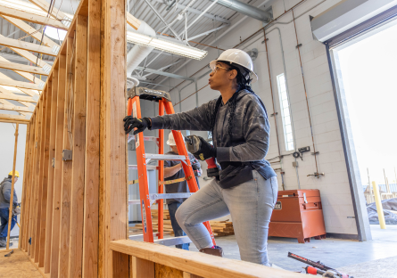 a woman construction worker framing a wall