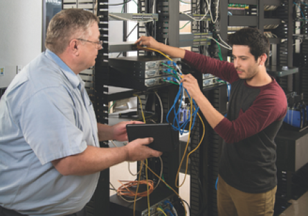 Image of a student and teacher working on IT servers