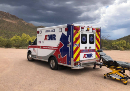 An image of an AMR ambulance and a stretcher in a desert setting 