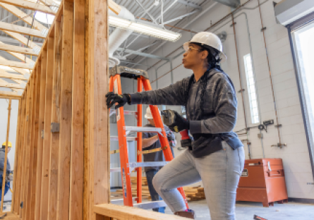 a woman construction worker framing a wall